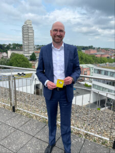 Hartmut Rohden, stellvertretender Vorstandsvorsitzender der Sparkasse Kaiserslautern hält den Kinderschutzpass in Händen. 